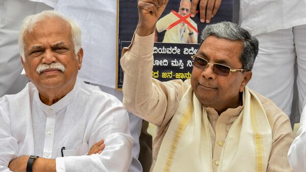 Senior Congress leader and former Chief Minister of Karnataka, Siddaramaiah (R), along with Congress legislators and leaders stage a demonstration at the Gandhi statue in Vidhana Soudha in Bangalore on September 18, 2019, against Bharatiya Janata Party (BJP) government for the delay in providing relief to the flood victims - Sputnik India
