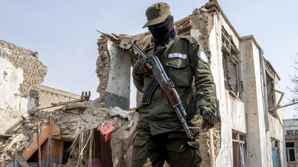 A Taliban fighter checks an Islamic State group house that was destroyed in the ongoing conflict between the two in Kabul, Afghanistan, Tuesday, Feb. 14, 2023. - Sputnik India