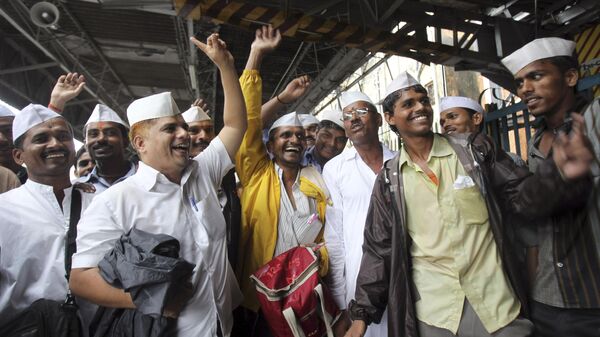Dabbawalas, or lunchbox delivery men, pass out sweets in celebration of the birth of the Prince of Cambridge, the son of Britain's Prince William and Kate, Duchess of Cambridge, at a railway platform in Mumbai, India, Tuesday, July 23, 2013. - Sputnik India