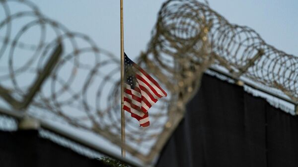 In this Aug. 29, 2021, file photo reviewed by U.S. military officials, a flag flies at half-staff in honor of the U.S. service members and other victims killed in the terrorist attack in Kabul, Afghanistan, as seen from Camp Justice in Guantanamo Bay Naval Base, Cuba. - Sputnik India