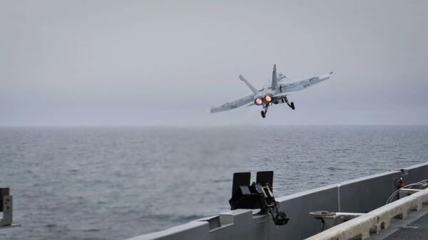 In this Wednesday, April 15, 2015 image released by U.S. Navy Media Content Services, an F/A-18E Super Hornet, assigned to the Knighthawks of Strike Fighter Attack Squadron 136, launches off the flight deck aboard Nimitz-class aircraft carrier USS Theodore Roosevelt in the Fifth Fleet area of operations - Sputnik India