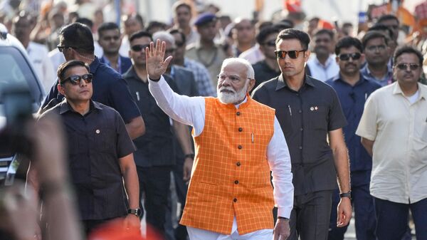 Indian Prime Minister Narendra Modi waves to people as he arrives to cast his vote during the third phase of general elections, in Ahmedabad, India, Tuesday, May 7, 2024.  - Sputnik India