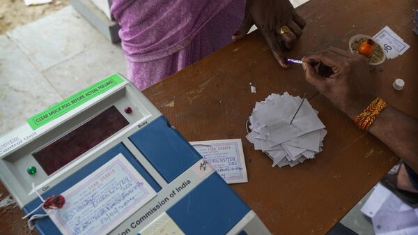 An election official applies indelible ink mark on the index finger on a woman voter during the fourth phase of general election, on the outskirts of Samastipur, in the Indian state of Bihar, Monday, May 13, 2024. - Sputnik India