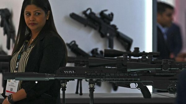 An exhibitor looks at sniper rifles kept on display at the Milipol India 2023 Internal Homeland Security Expo in New Delhi on October 26, 2023. - Sputnik India